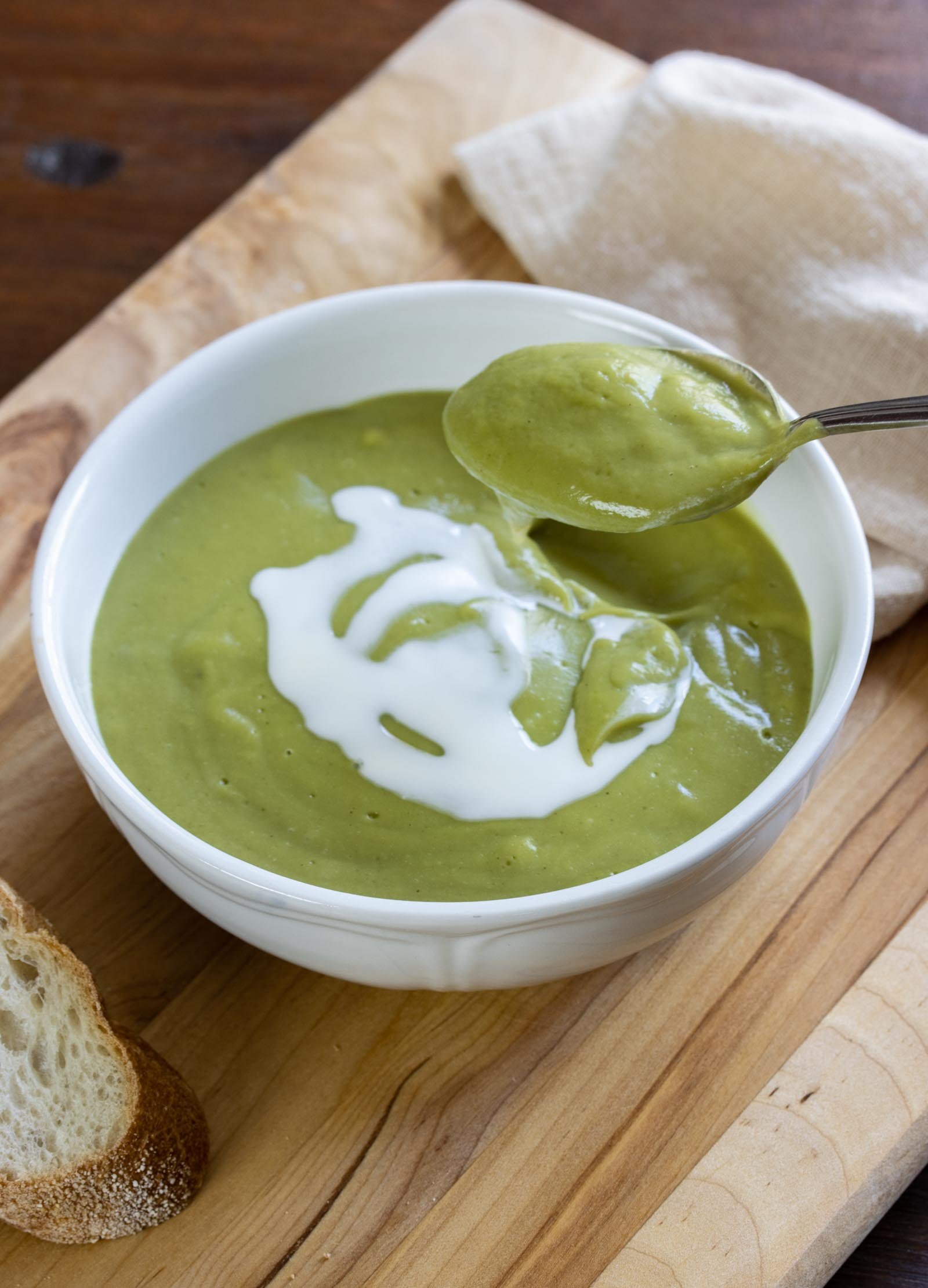 Creamy Watercress Soup a spoonful of Creamy Watercress Soup on as board served alongside bread, napkin